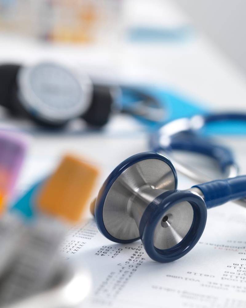 A stethoscope resting on printed medical lab results