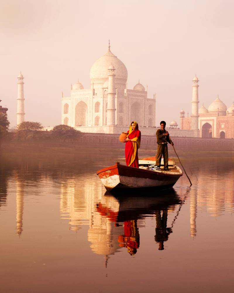 The Taj Mahal reflected in the water at dawn in Agra, India