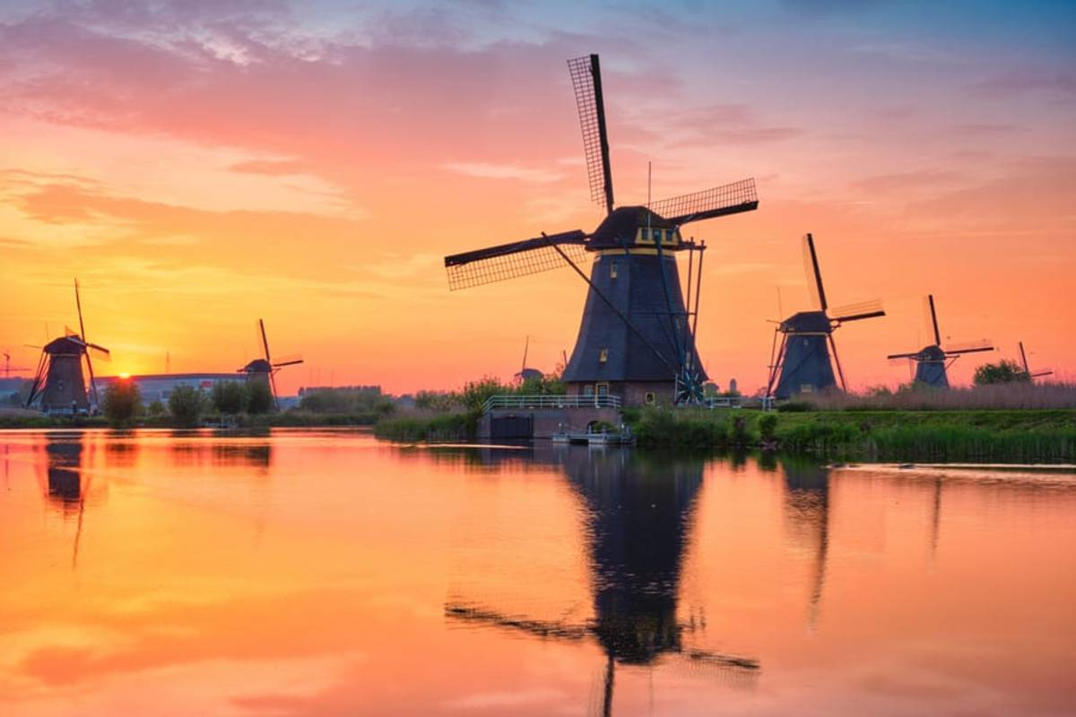 The Kinderdijk windmills reflected in the canal at sunrise, Netherlands