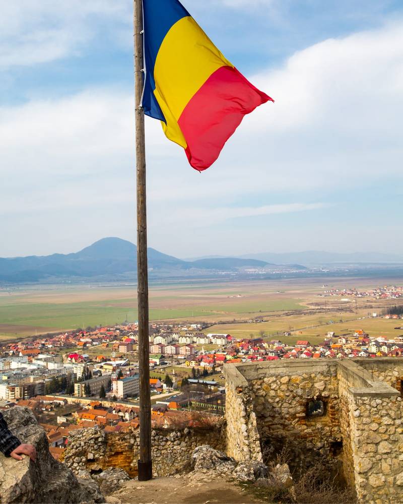 Rasnov citadel on the hillside with the Romanian flag, Romania