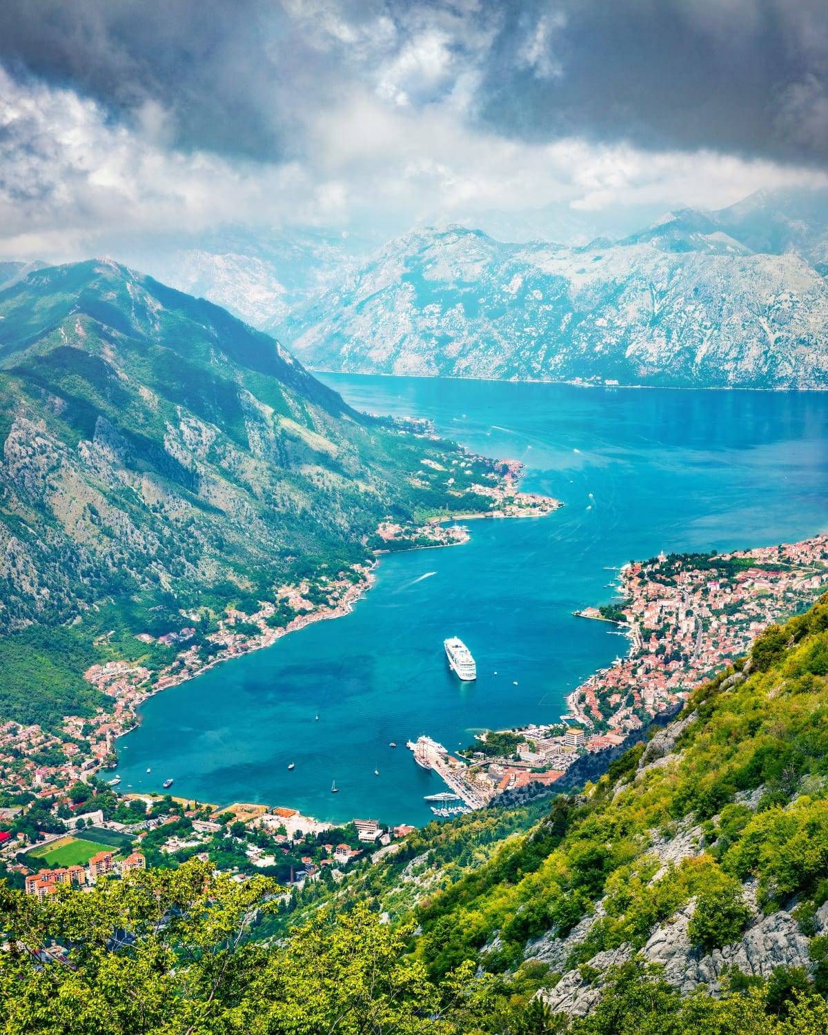 Luftaufnahme der Bucht von Kotor mit einem Kreuzfahrtschiff zwischen den Bergen, Montenegro