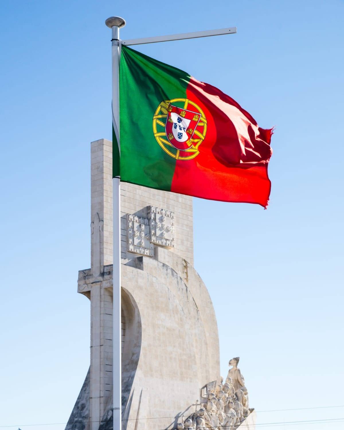 Die portugiesische Flagge weht über dem Denkmal der Entdeckungen in Lissabon, Portugal