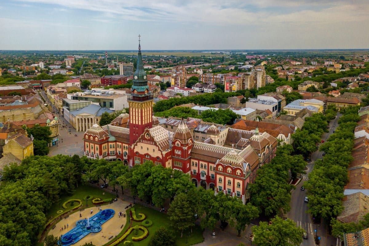 Aerial view of Subotica's Art Nouveau City Hall and its fountain garden, with the town spreading out behind.