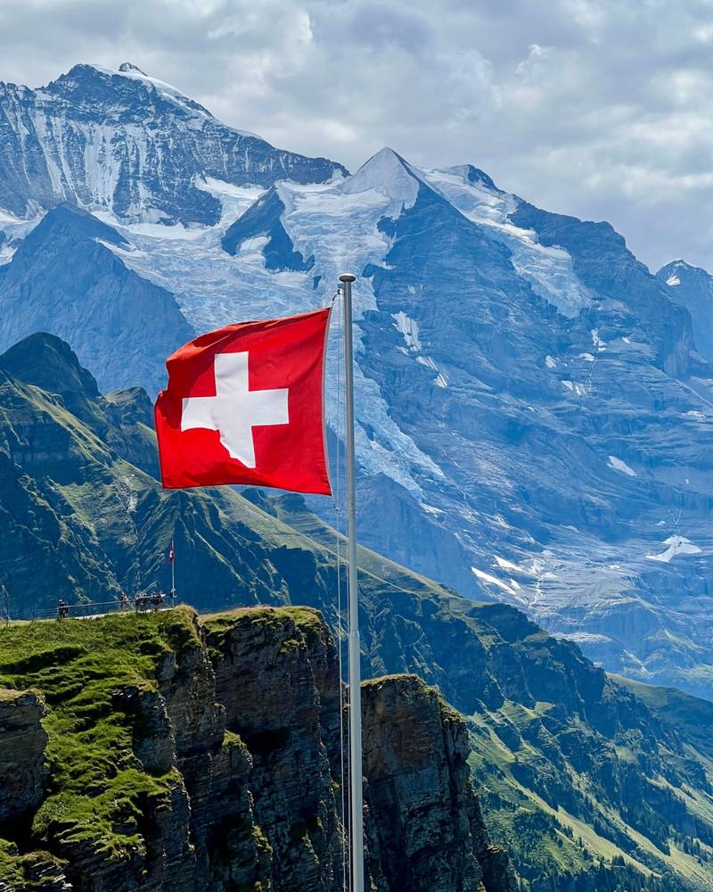 The Swiss flag above the Bernese Alps near the Jungfrau, Switzerland